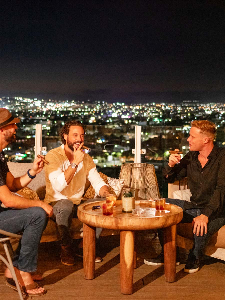 Chicos fumando puros en la azotea.