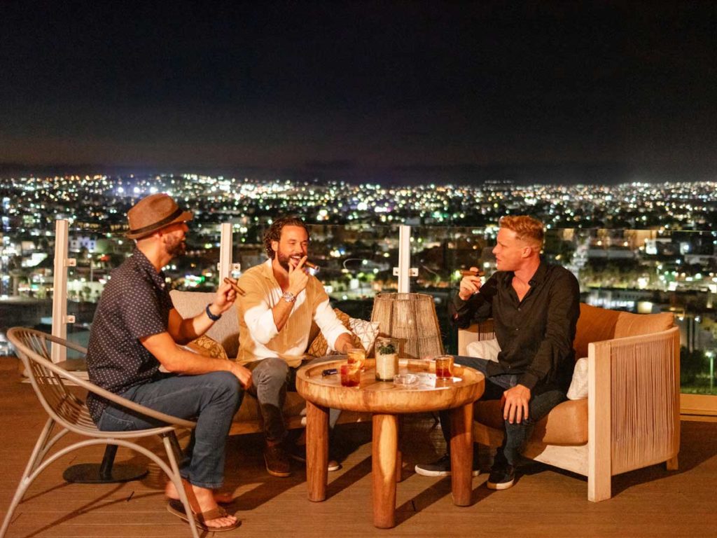 Guys Lounging On The Rooftop At Night.