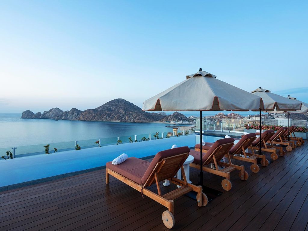 Lounge Chairs On The Pool Deck With An Ocean View.