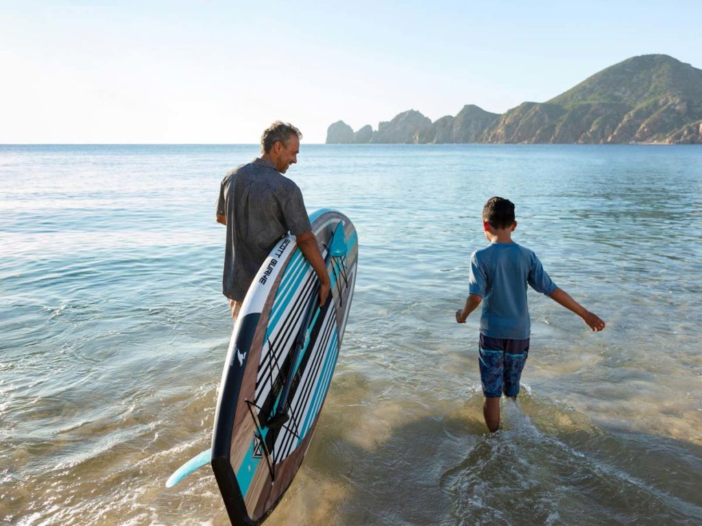 Papá e hijo haciendo paddleboarding.