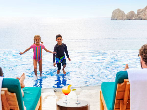 Kids Playing In The Pool By The Ocean.