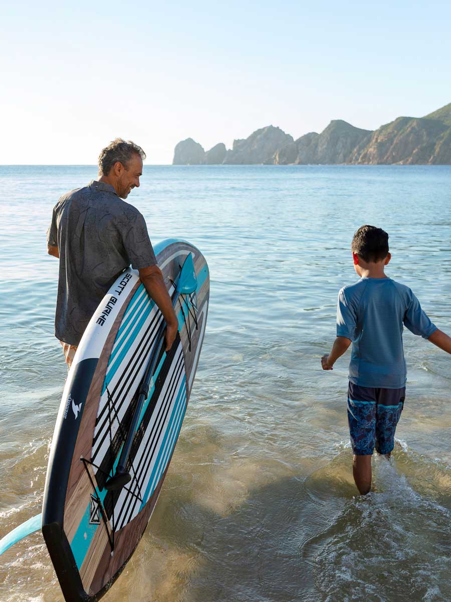 Papá e hijo haciendo paddleboarding en Cabo.