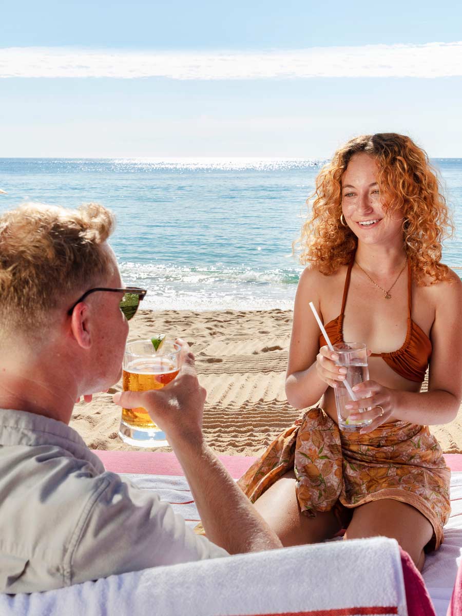 Couple On The Beach With A Drink.