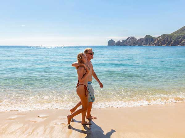 Couple Walking On The Beach In Cabo.