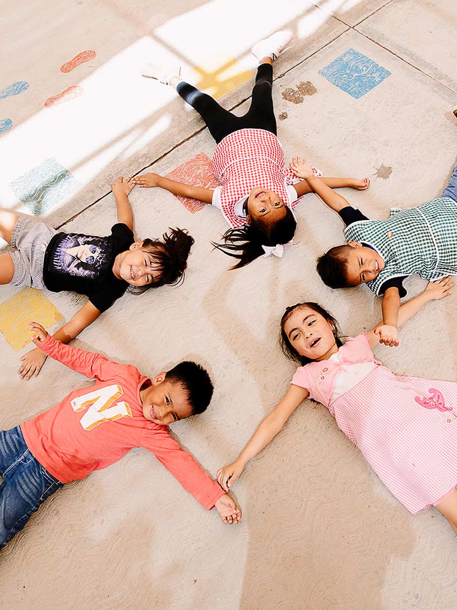 Niños tumbados en el suelo haciendo una estrella.