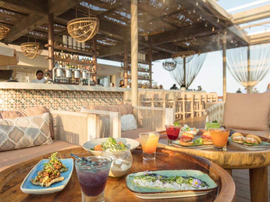 Table With Food And Drinks By The Ocean.