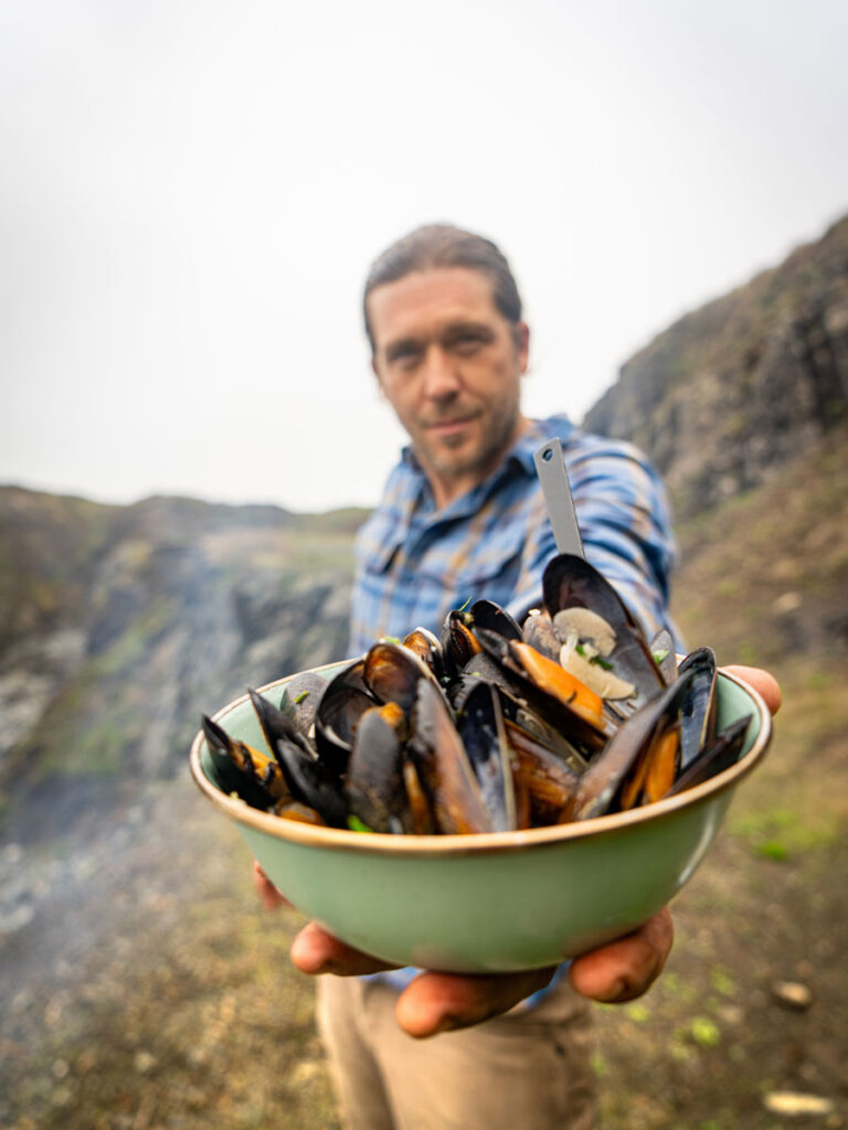man holding a bolw of clams
